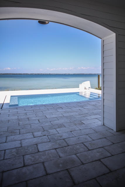 View of pool and Perdido Bay from breezeway in custom home by Highpointe DBR, LLC